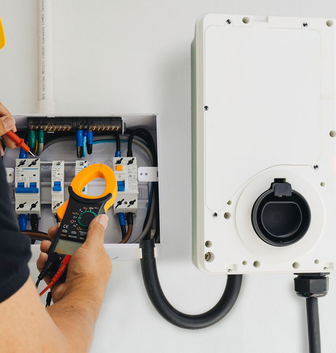 Elektriker prüft Wallbox-Installation mit Strommessgerät